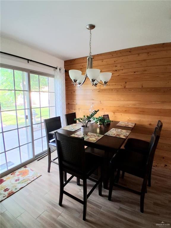 613 W Sprague St, Edinburg, TX 78539 - dining room featuring a chandelier, wooden walls, and light wood finished floors