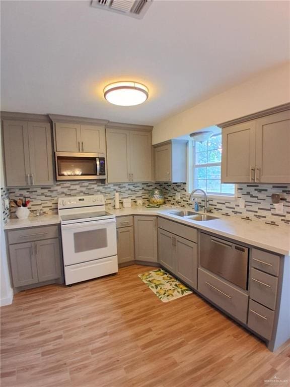 613 W Sprague St, Edinburg, TX 78539 - kitchen with stainless steel appliances, gray cabinetry, a sink, and decorative backsplash