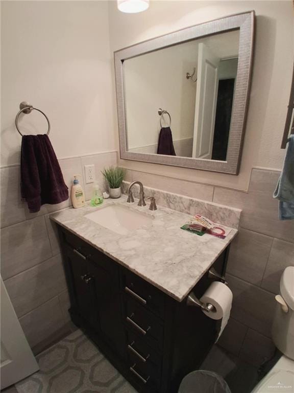 613 W Sprague St, Edinburg, TX 78539 - bathroom featuring tile walls, vanity, wainscoting, toilet, and tile patterned floors