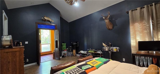 bedroom featuring baseboards, wood finished floors, and vaulted ceiling