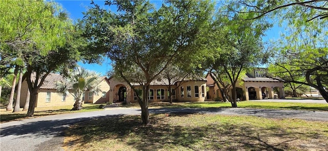 mediterranean / spanish house with a front lawn