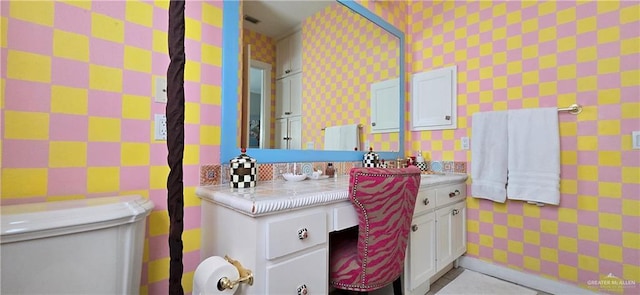 bathroom with wallpapered walls and vanity