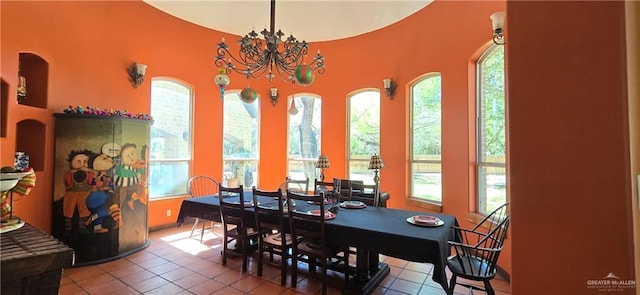 dining area featuring tile patterned floors and a chandelier