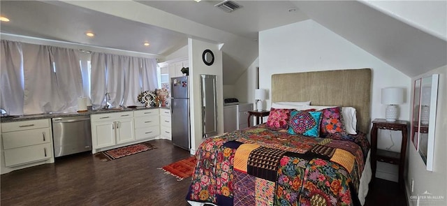 bedroom featuring visible vents, washing machine and clothes dryer, dark wood-style flooring, freestanding refrigerator, and vaulted ceiling