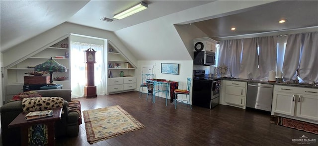 interior space featuring dark wood finished floors, vaulted ceiling, built in features, and visible vents