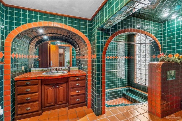 27101 N State Highway 345, San Benito, TX 78586 - bathroom with tile patterned flooring, vanity, ornamental molding, tile walls, and a tile shower