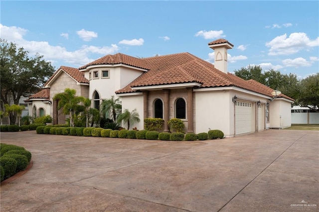 mediterranean / spanish home featuring a garage