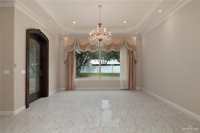 unfurnished dining area with a tray ceiling, ornamental molding, and an inviting chandelier