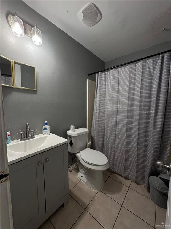 bathroom featuring walk in shower, tile patterned flooring, vanity, and toilet