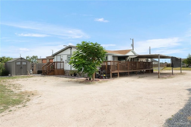 exterior space featuring a wooden deck, a carport, and a storage unit