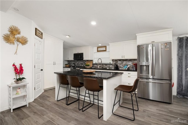 kitchen featuring a center island, white cabinetry, dark wood-type flooring, and appliances with stainless steel finishes