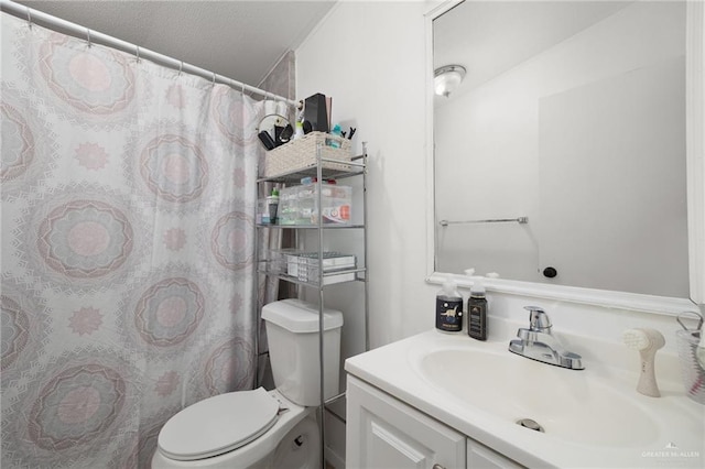 bathroom featuring vanity, toilet, and a textured ceiling