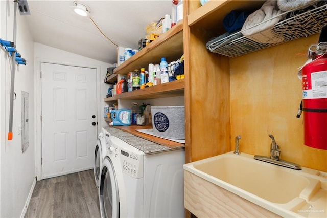 laundry room featuring hardwood / wood-style floors, washer and dryer, and sink