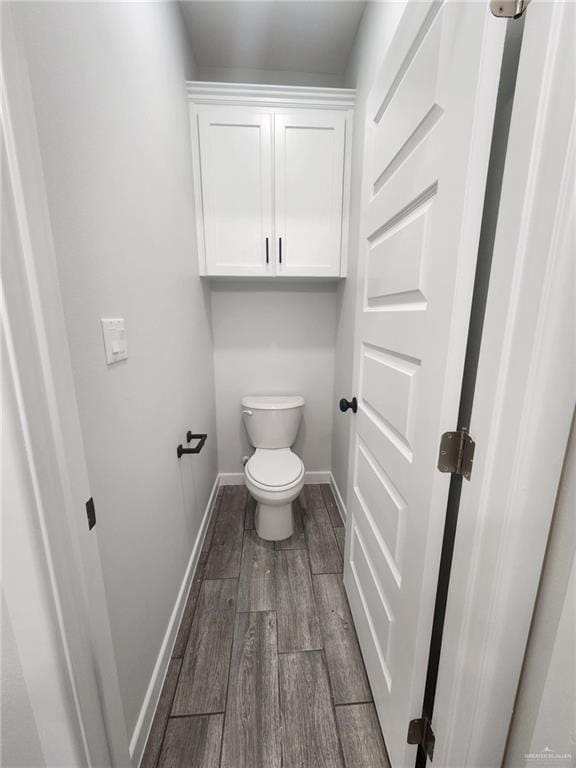 bathroom with hardwood / wood-style flooring and toilet