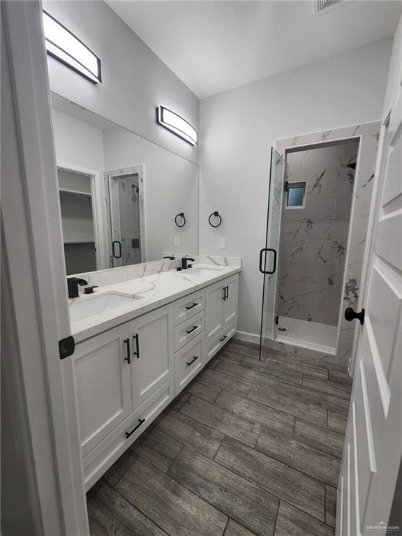 bathroom with vanity, hardwood / wood-style flooring, and a shower with door