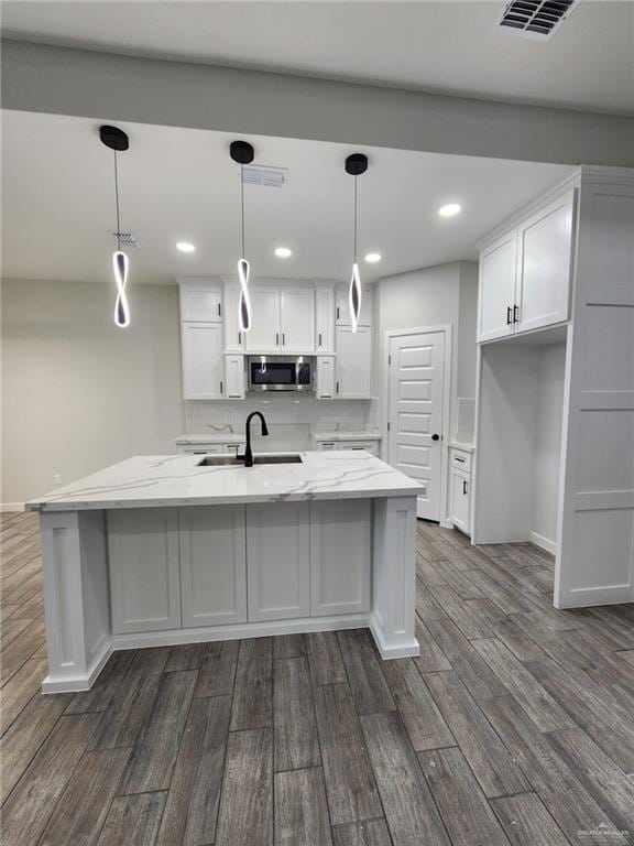 kitchen featuring sink, white cabinets, pendant lighting, and dark hardwood / wood-style floors