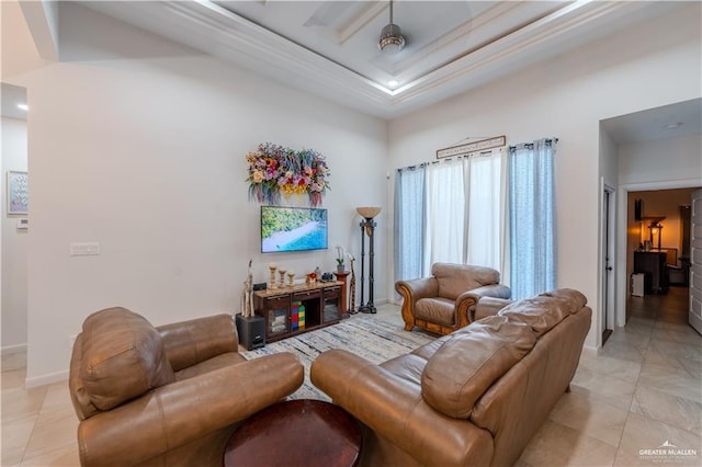 living area with a towering ceiling, light tile patterned floors, baseboards, and a tray ceiling