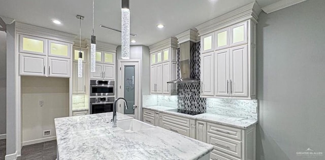 4609 Resaca N St, Harlingen, TX 78552 - kitchen featuring white cabinets, tasteful backsplash, black electric cooktop, wall chimney exhaust hood, and an island with sink