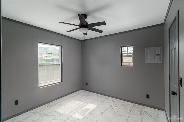 empty room featuring marble finish floor, crown molding, a ceiling fan, electric panel, and baseboards