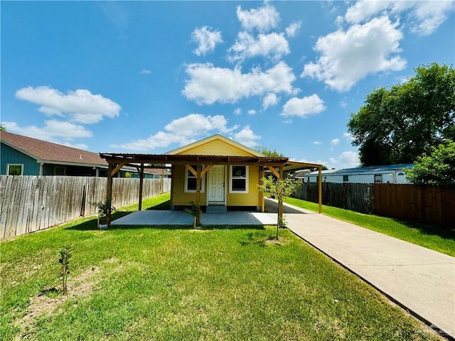 rear view of house featuring an attached carport, a fenced backyard, and a lawn