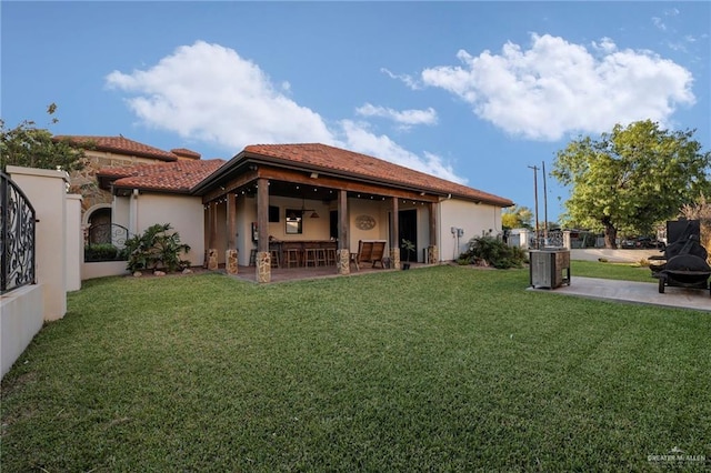 back of property featuring a patio, stucco siding, fence, and a lawn