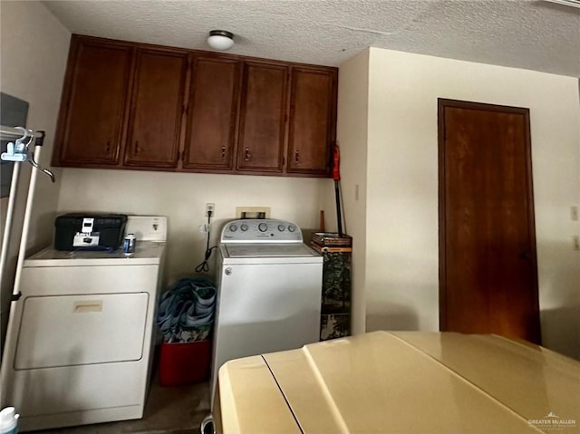 clothes washing area featuring cabinets, a textured ceiling, and independent washer and dryer