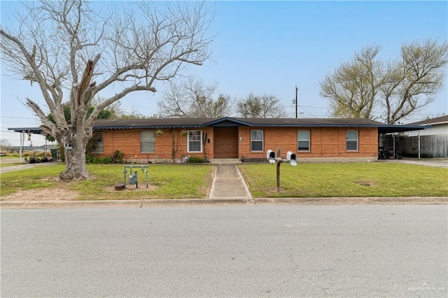 ranch-style home with a carport, a front yard, and driveway