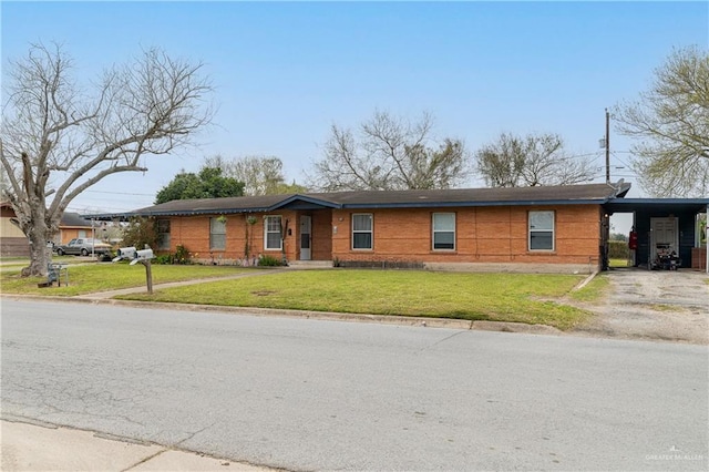 ranch-style house featuring an attached carport, driveway, and a front lawn