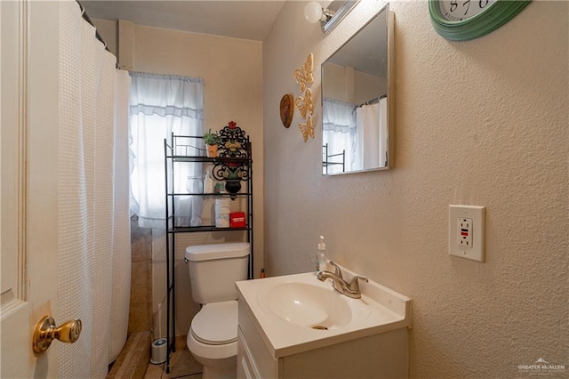 full bath with toilet, a textured wall, curtained shower, and vanity