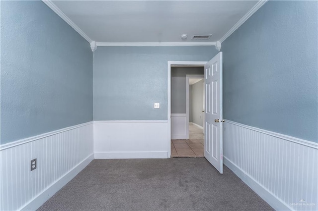 carpeted spare room featuring crown molding