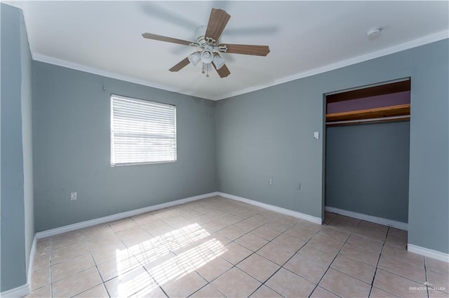 unfurnished bedroom featuring ceiling fan, light tile patterned flooring, ornamental molding, and a closet