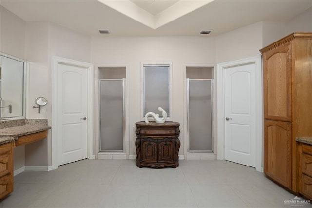 bathroom featuring tile patterned floors, vanity, and walk in shower