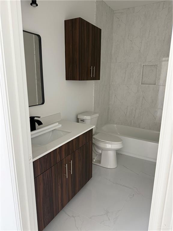 5320 Vision, Rio Grande City, TX 78582 - bathroom featuring vanity, marble look tiles, toilet, and bathtub / shower combination