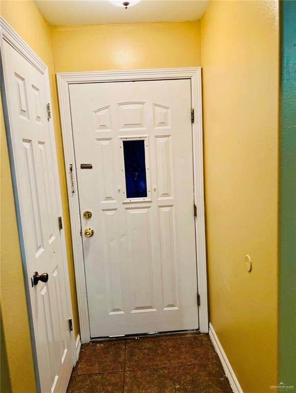 doorway to outside featuring dark tile patterned floors