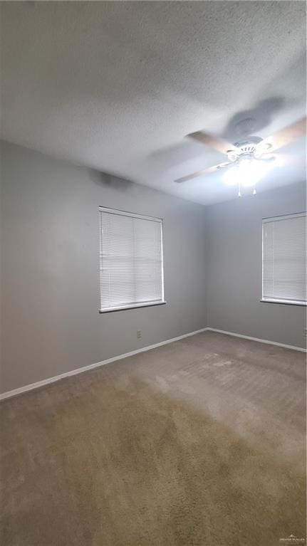 carpeted spare room featuring a textured ceiling and ceiling fan