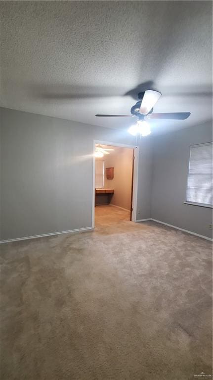 carpeted spare room with ceiling fan and a textured ceiling