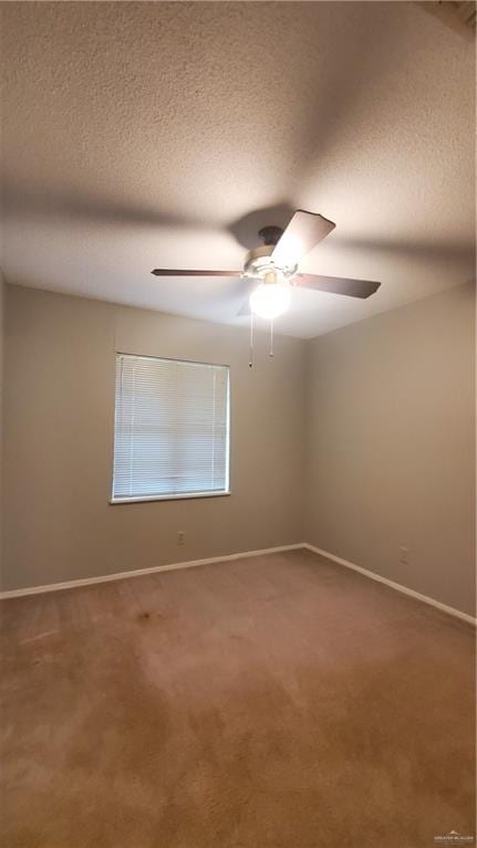 carpeted spare room with a textured ceiling and ceiling fan