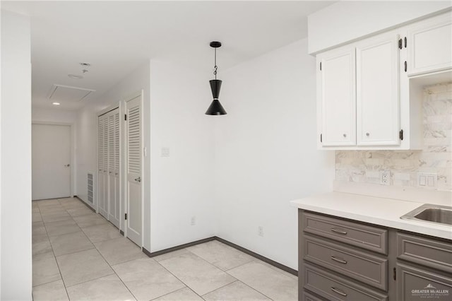 2115 S 3rd St, Mcallen, TX 78503 - kitchen with white cabinets, decorative backsplash, light countertops, hanging light fixtures, and light tile patterned floors