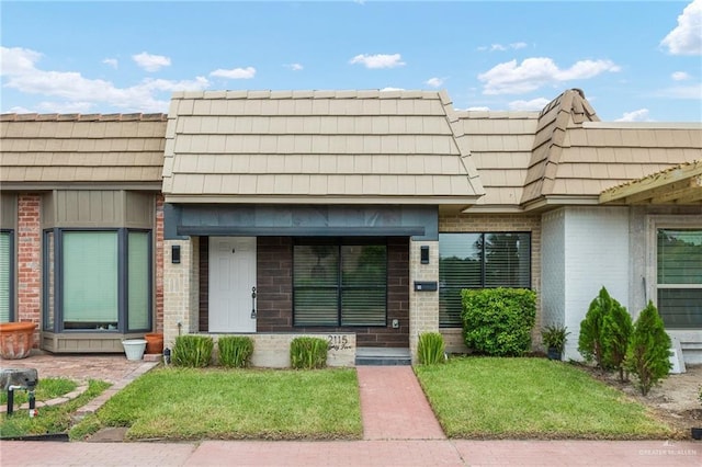 2115 S 3rd St, Mcallen, TX 78503 - view of front of home featuring brick siding, mansard roof, a front yard, and a porch