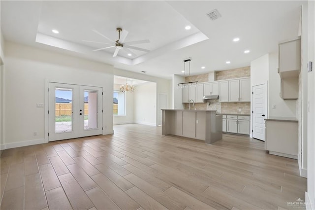 403 Faith Dr, La Feria, TX 78559 - kitchen with tasteful backsplash, ceiling fan with notable chandelier, visible vents, a raised ceiling, and open floor plan