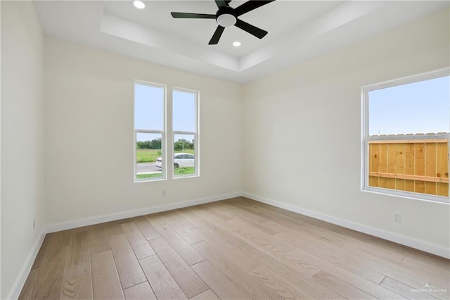 403 Faith Dr, La Feria, TX 78559 - unfurnished room with baseboards, hardwood / wood-style floors, ceiling fan, and a tray ceiling