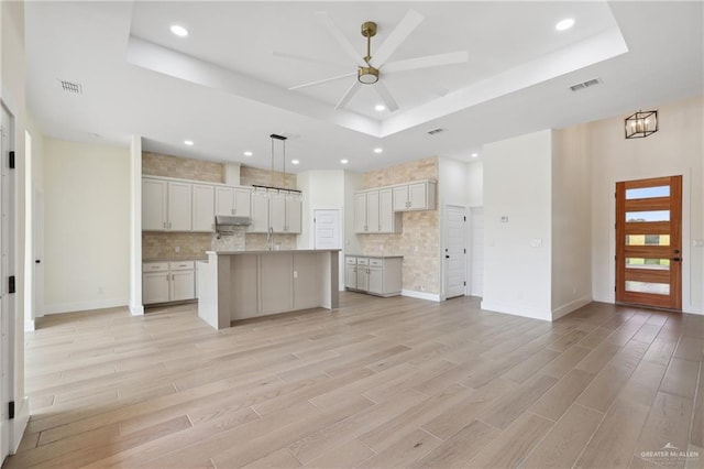 403 Faith Dr, La Feria, TX 78559 - kitchen with a ceiling fan, visible vents, a raised ceiling, and decorative backsplash