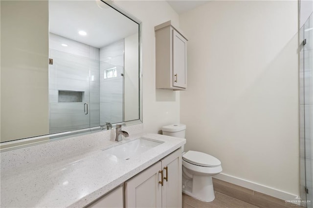 403 Faith Dr, La Feria, TX 78559 - bathroom featuring toilet, vanity, a shower stall, and wood finished floors