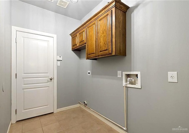 1915 Bunting Ln, Mission, TX 78572 - laundry room with electric dryer hookup, washer hookup, cabinet space, and light tile patterned floors