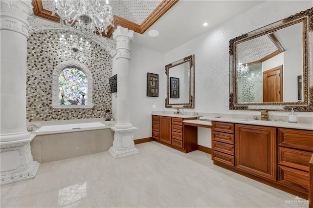 bathroom featuring tiled bath, vanity, and ornate columns