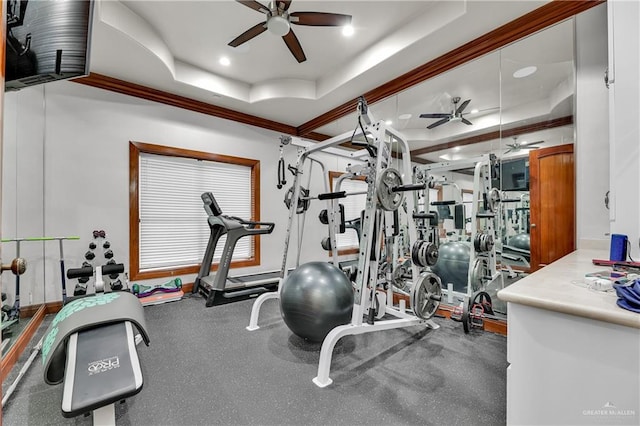 exercise room with a raised ceiling, ceiling fan, and crown molding