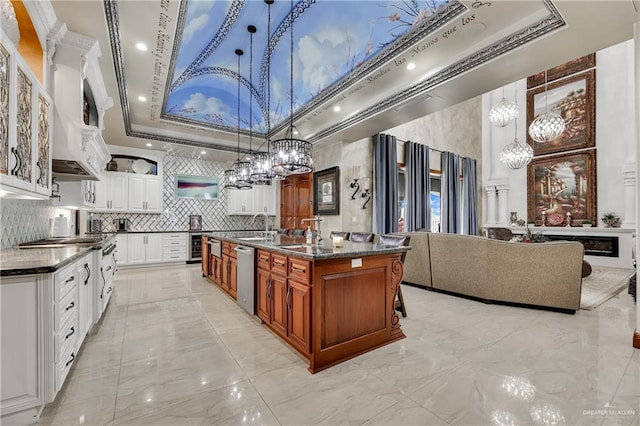 kitchen featuring stainless steel dishwasher, a large island, white cabinetry, and decorative light fixtures