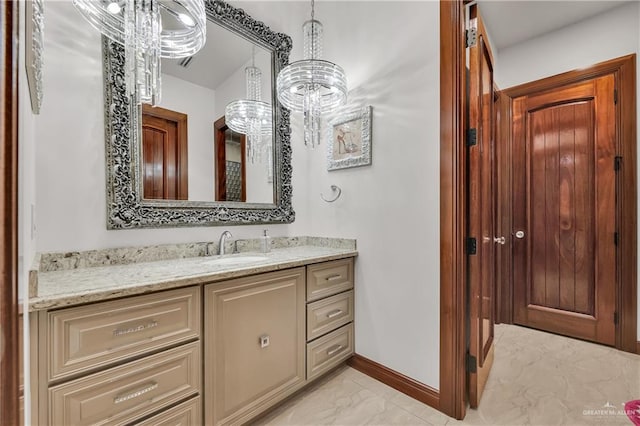 bathroom featuring a notable chandelier and vanity