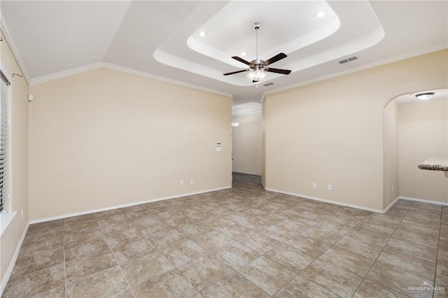 empty room featuring crown molding, a tray ceiling, and ceiling fan