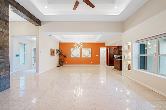 unfurnished living room featuring a raised ceiling and ceiling fan with notable chandelier